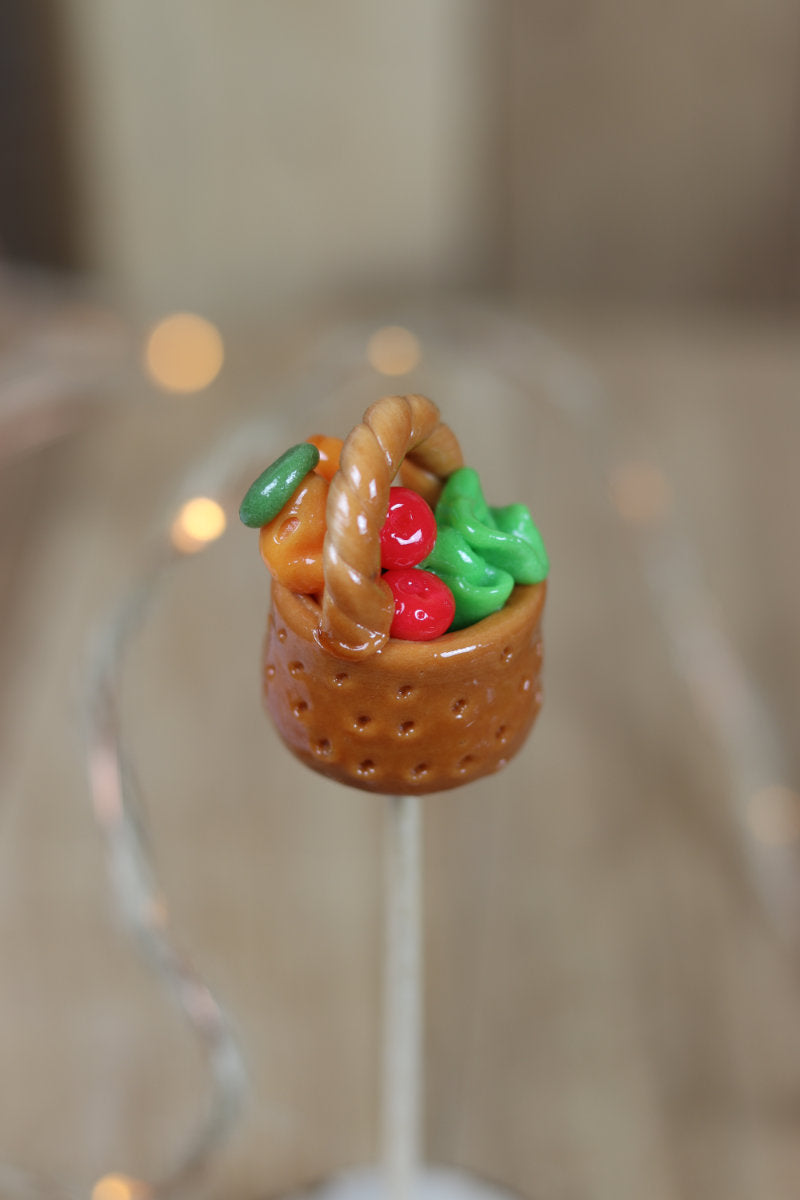 Sucette sculptee en forme de panier de légume, en sucre cuit aromatisé avec divers fruit. 