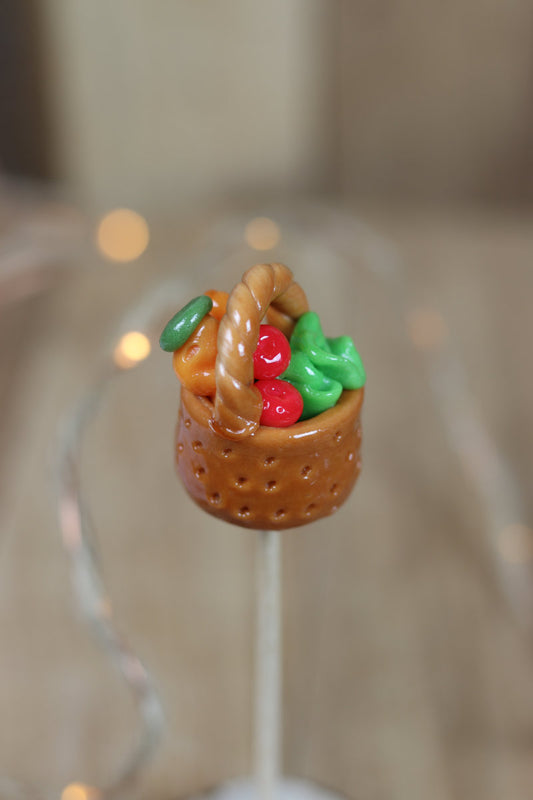 Sucette sculptee en forme de panier de légume, en sucre cuit aromatisé avec divers fruit. 