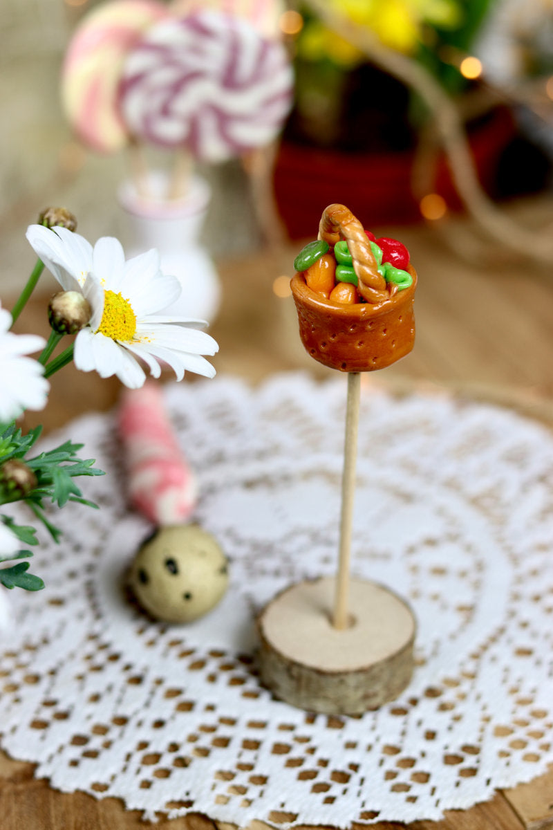Sucette sculptee en forme de panier de légume, en sucre cuit aromatisé avec divers fruit. Dans un décor printanier