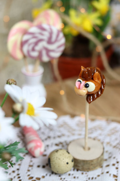 Sucette sculptée à la main en forme de cheval au caramel avec un papillon sur le nez dans un décor printanier