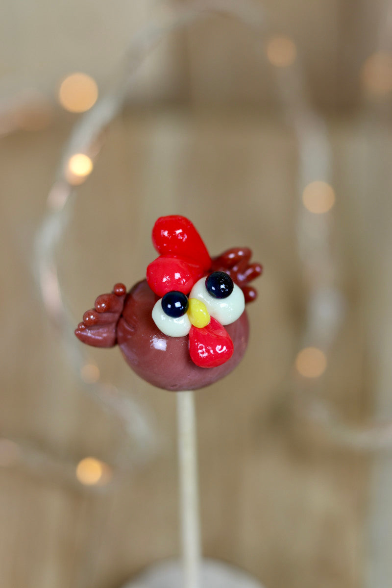 Sucette en sucre cuit sculptée en forme de poule au cacao et à la framboise