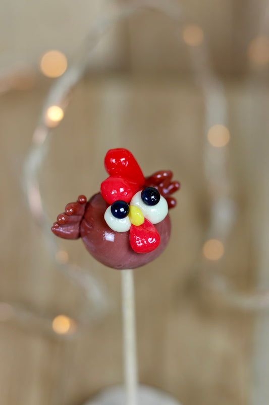 Sucette en sucre cuit sculptée en forme de poule au cacao et à la framboise