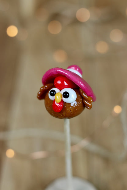 Sucette sculptée en forme de poule au cola avec un chapeau à la cerise