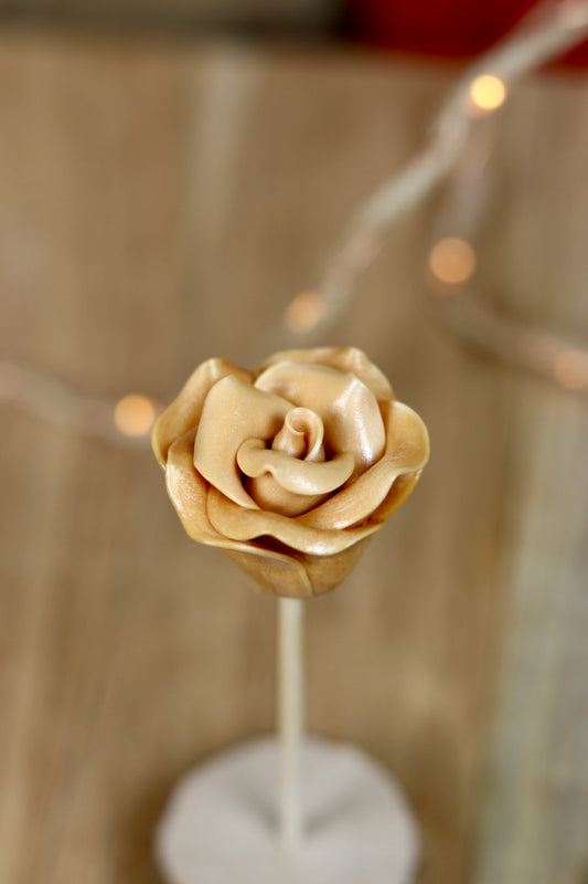 Sucette sculptée à la mai en forme de rose au caramel beurre salé
