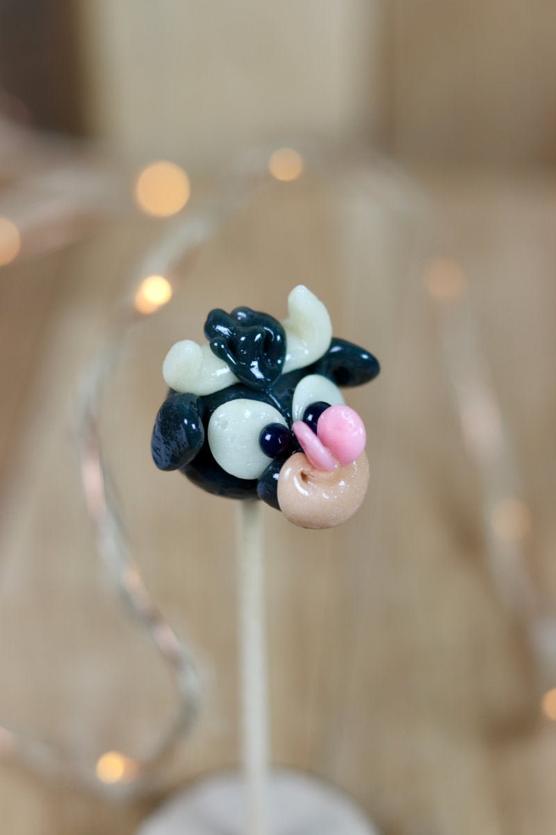 Sucette sculptée en forme de taureau au cola avec un papillon sur le nez