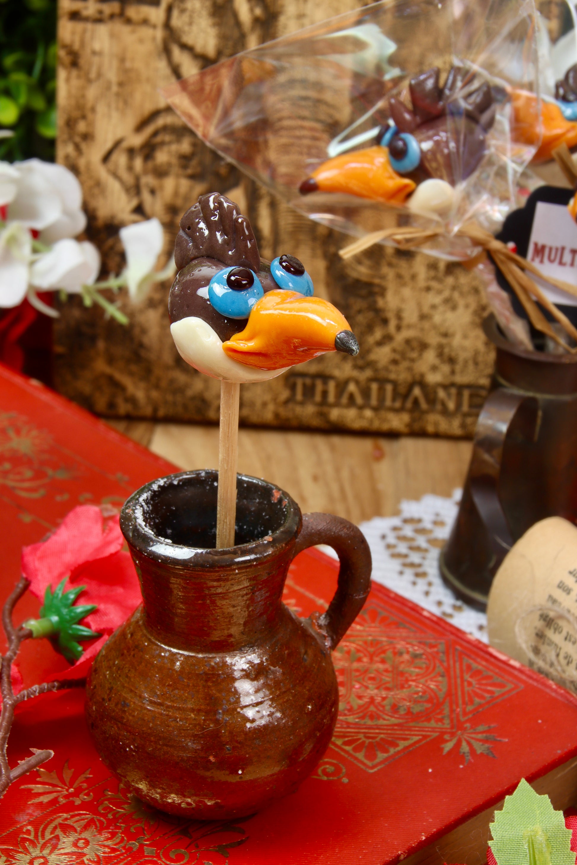 Une sucette sculptée en forme de toucan aux saveurs multifruit dans un décor de jungle
