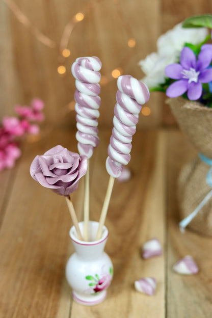 Bouquet de sucette à la violette et au citron. Une sucette sculptée en forme de fleur à la violette et deux torsade à la violette et au citron. Dans un décor magique