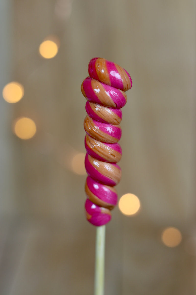 Une sucette torsade cerise cola artisanale fabriqué dans notre atelier en Bourgogne