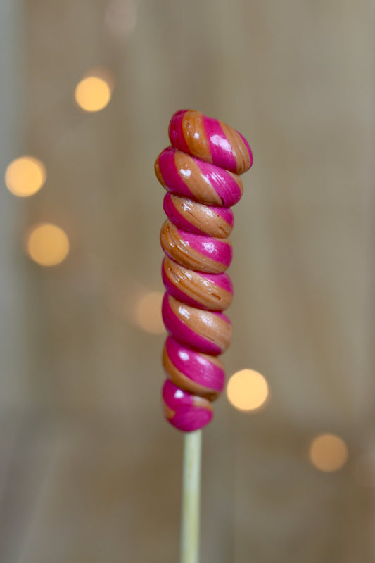 Une sucette torsade cerise cola artisanale fabriqué dans notre atelier en Bourgogne