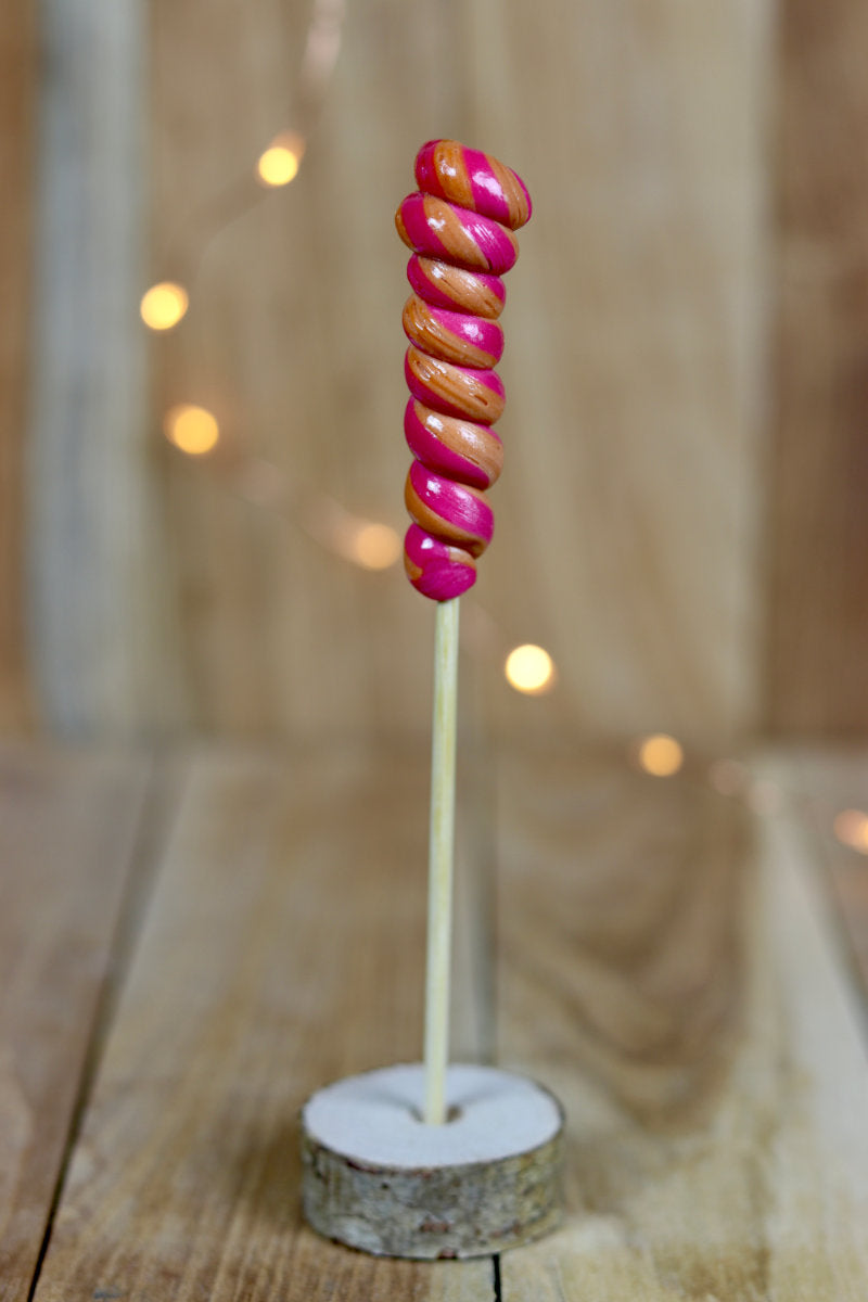 Une sucette torsade cerise cola artisanale fabriqué dans notre atelier en Bourgogne