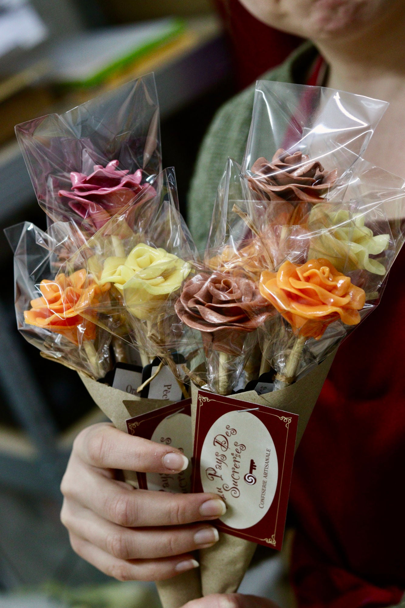 Un bouquet de sucettes en forme de fleurs dans un vase. Des fleurs en sucre cuit aromatisées avec des arômes naturels. Emballé dans des feuille kraft prêt à offrir