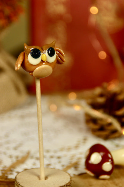 Sucette sculptée en forme de hibou marron dans un déco féérique