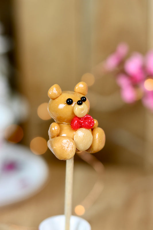 sucette en forme de peluche au caramel beurre salé avec un noeud papillon