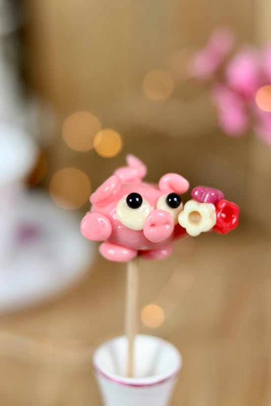 une sucette en forme de cochon à la fraise qui offre un bouquet de fleur pour la saint valentin