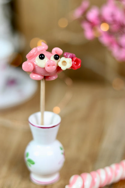 une sucette en forme de cochon à la fraise qui offre un bouquet de fleur pour la saint valentin