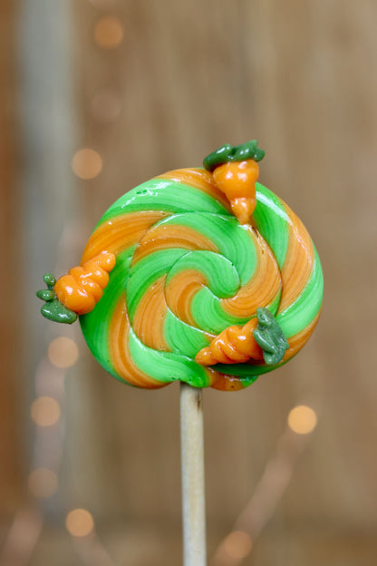 Sucette foraine traditionnel pomme orange avec des carottes sculptée en sucre cuit dessus