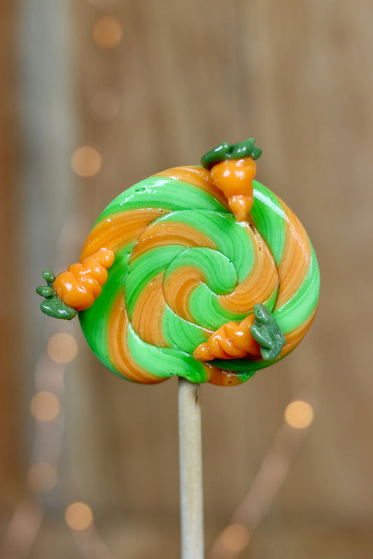 Sucette foraine traditionnel pomme orange avec des carottes sculptée en sucre cuit dessus