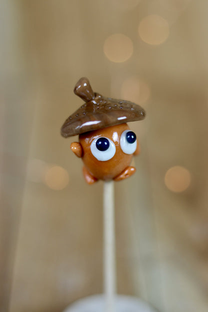 Une sucette sculptée en forme de gland au cola, pour une décoration automne ou forêt