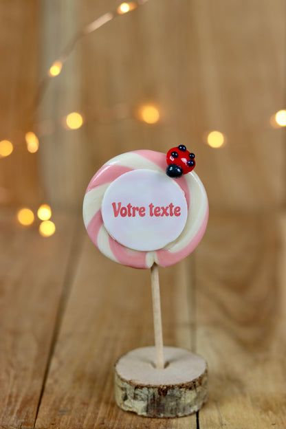 sucette imprimée à personnaliser vanille fraise avec une coccinelle dessus. Dans un décor féérique