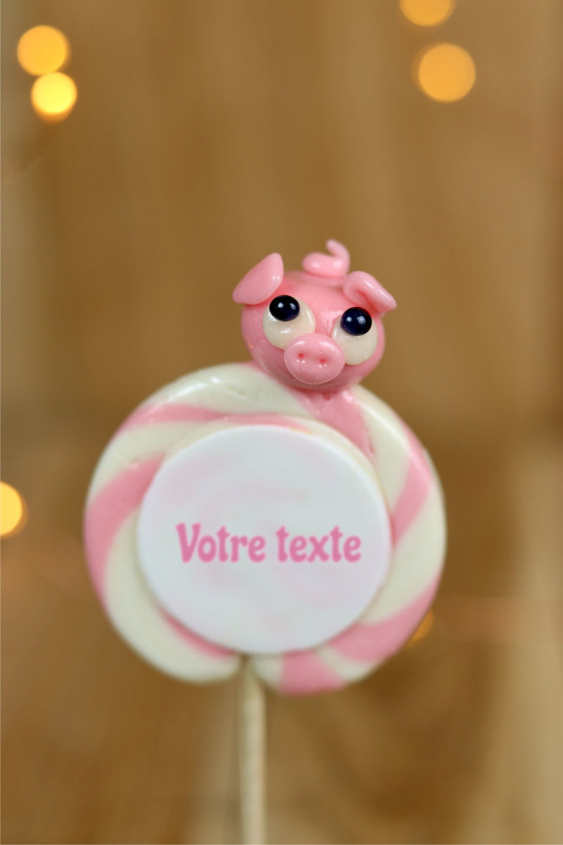 Sucette imprimée à personnaliser de votre texte, à la vanille et à la fraise avec un cochon sculptée en sucre cuit dessus