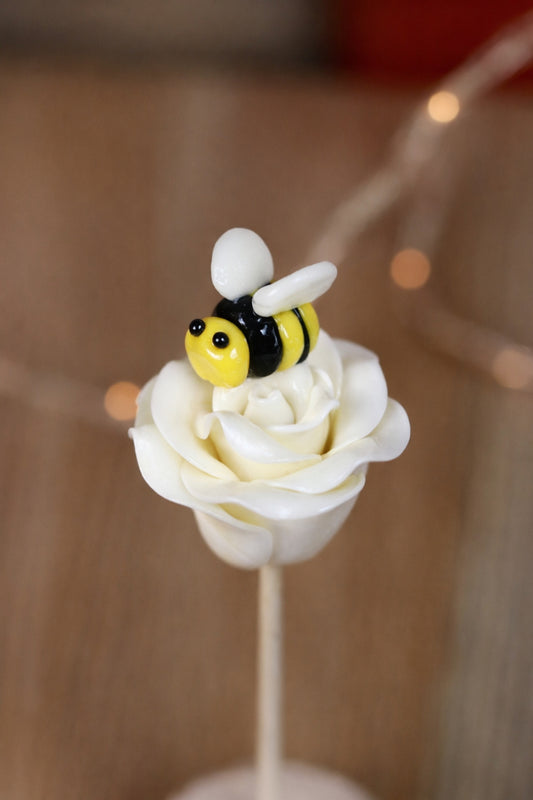 Sucette sculptée en forme de rose blanche au citron avec une abeille caisse citron qui butine dessus